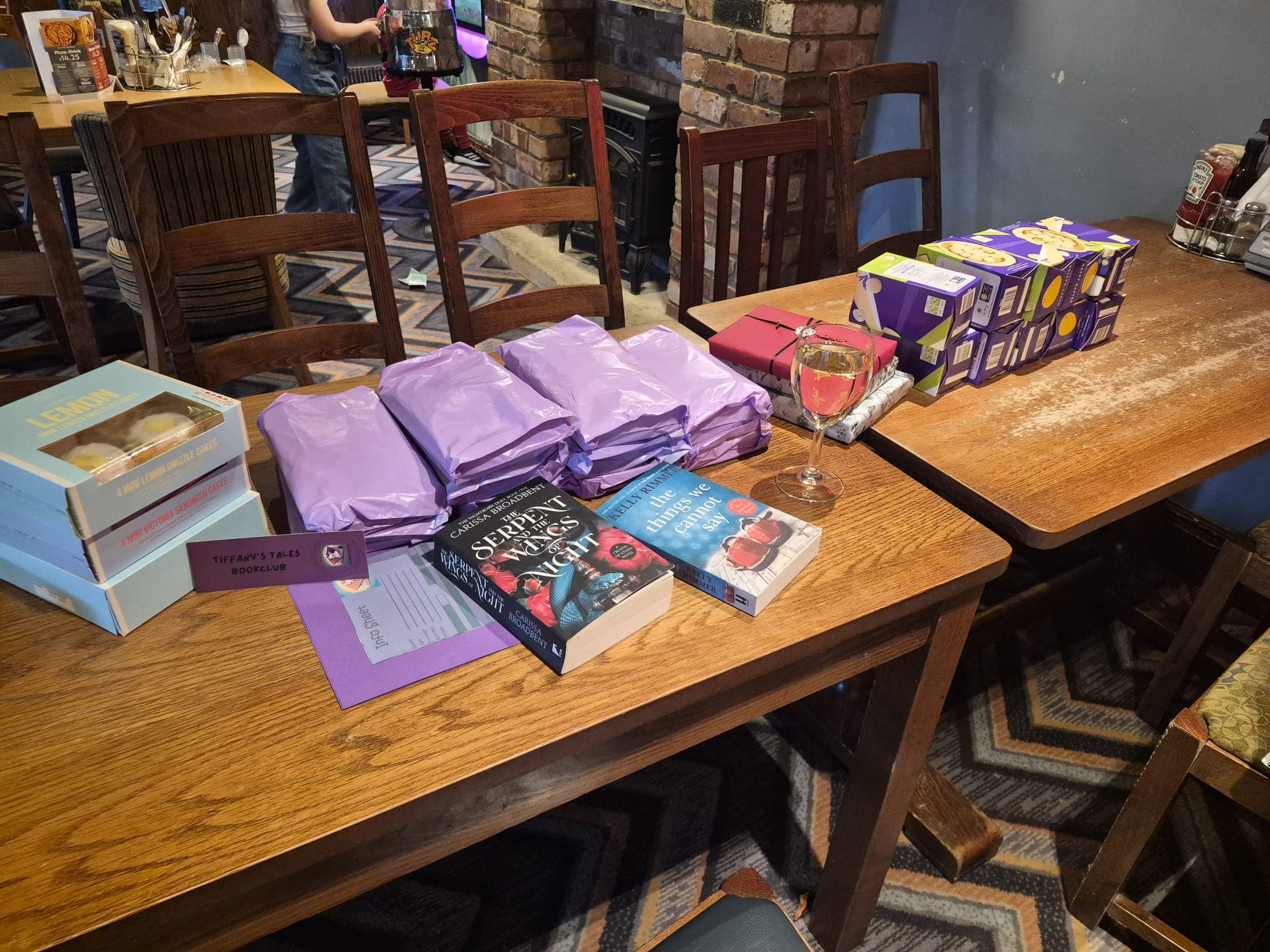 A meet-up table set with the month's books and Tiffany's Tales goodie bags